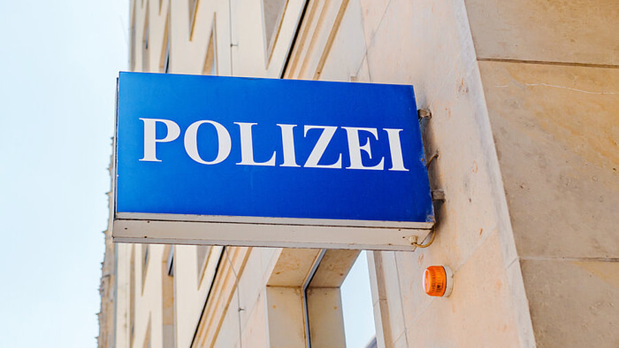 Polizei-Zeichen an einer Hauswand