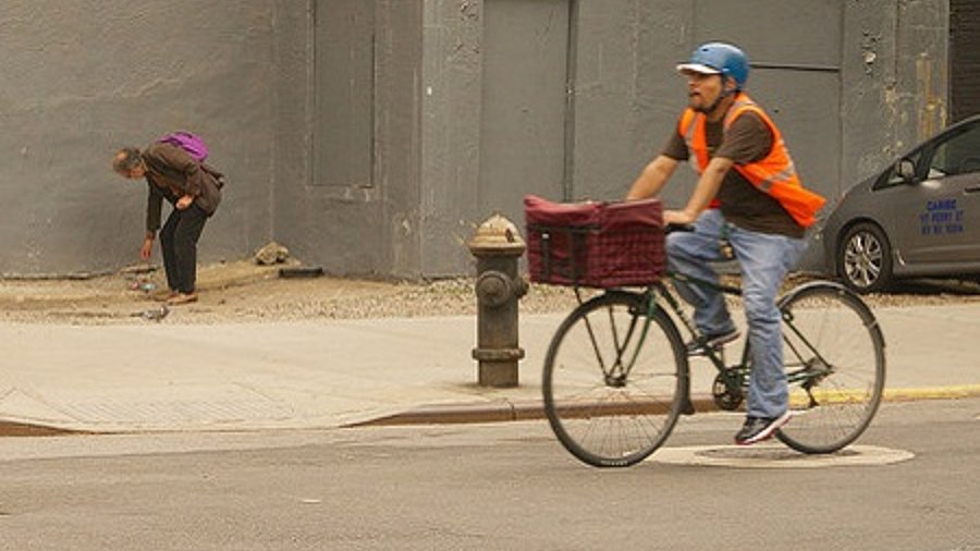 Mann auf fahrrad fährt Paket aus