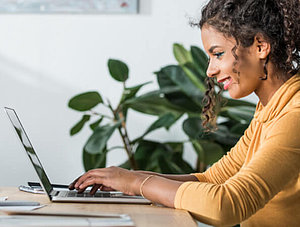 Frau sitzt am Laptop