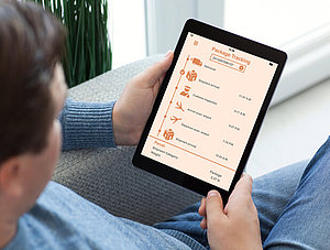 App Paket-Tracking, Mann sitzt auf Sofa mit Tablet