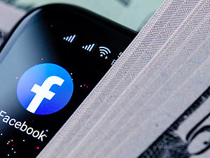 Facebook auf einem Smartphone mit Geld