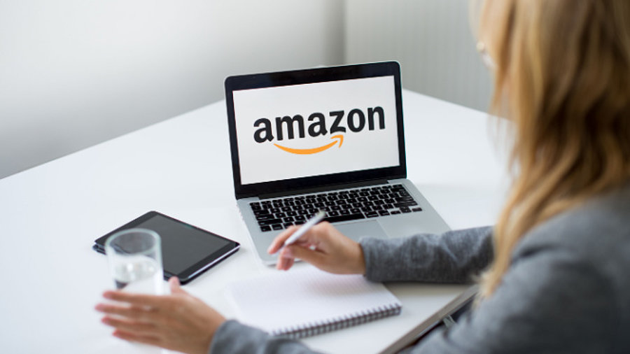 Frau an Laptop mit Amazon-Logo