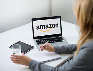 Frau an Laptop mit Amazon-Logo