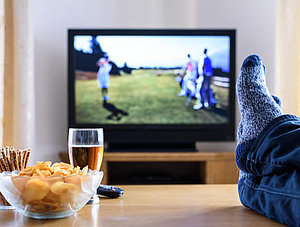 Fernseher und Tisch mit Füßen darauf