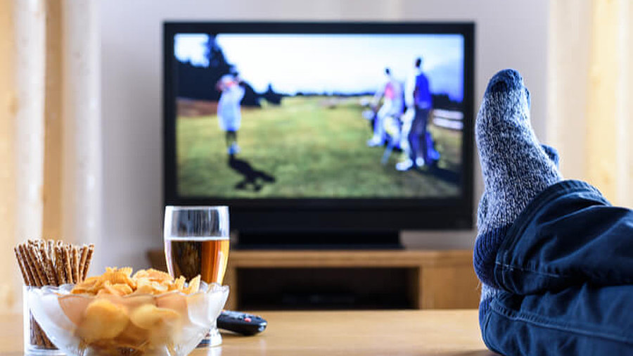 Fernseher und Tisch mit Füßen darauf