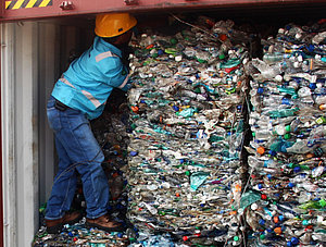 Arbeiter auf M&uuml;llbergen in Container