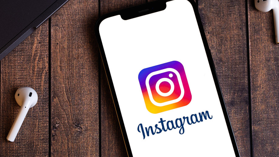 Instagram-Logo auf Smartphone. Neben dem Smartphone liegt ein Kopfh&ouml;rer