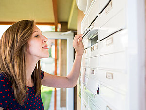 Frau und Briefkasten