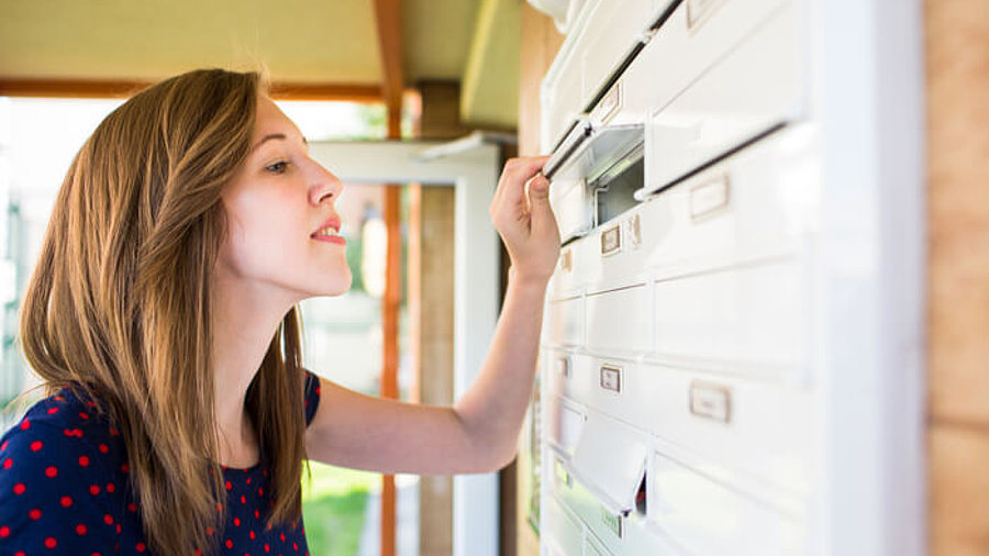 Frau und Briefkasten