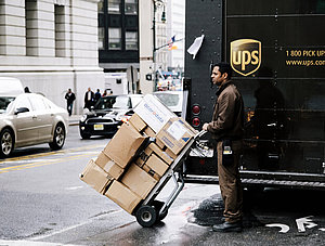 UPS Bote vor Paketauto mit Paketen