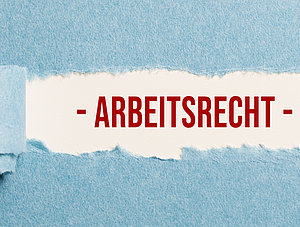 Zerrissenes Papier gibt den Schriftzug "Arbeitsrecht" frei