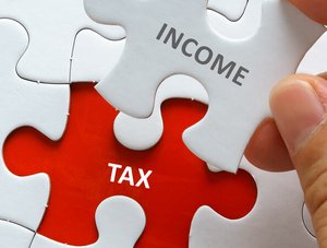 Puzzleteil wird gesetzt. Teil tr&auml;gt die Aufschrift INCOME; rote L&uuml;cke tr&auml;gt den Schriftzug TAX.