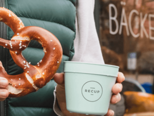 Frau mit Recup-Becher und Breze