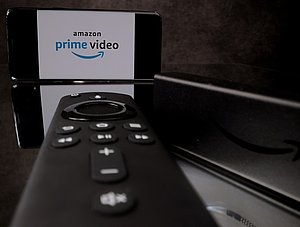 Amazon Prime Video Logo auf Smartphone und Fire TV Fernbedienung