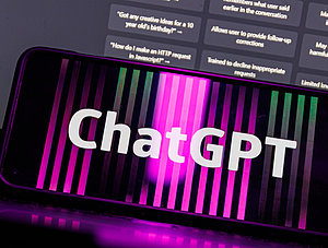 ChatGPT auf Smartphone vor Laptop