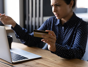 Frau vor Laptop mit Bankkarte