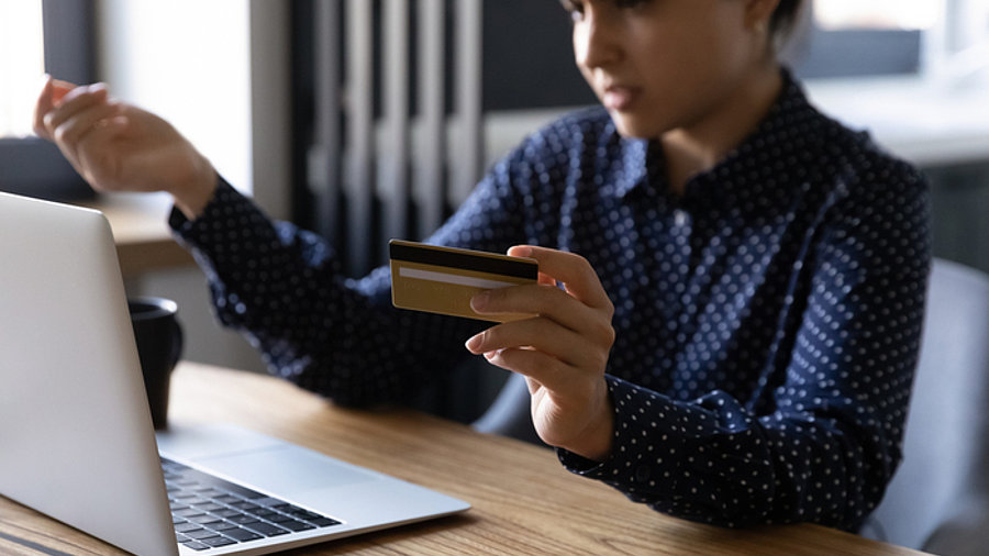 Frau vor Laptop mit Bankkarte