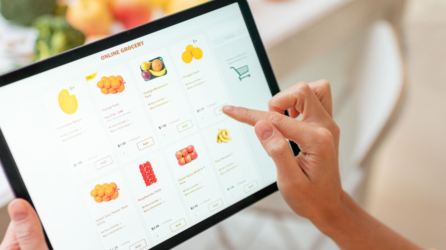 Person shoppt Lebensmittel auf dem Tablet