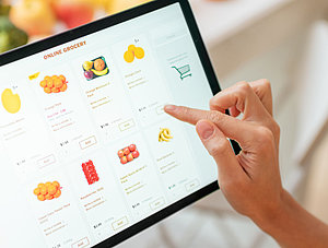 Person shoppt Lebensmittel auf dem Tablet