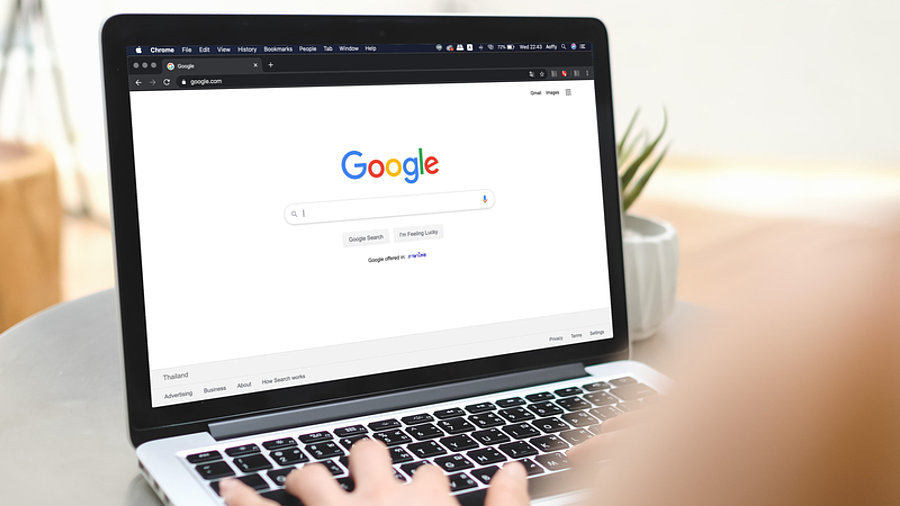 Person mit Laptop ruft Google-Suche auf