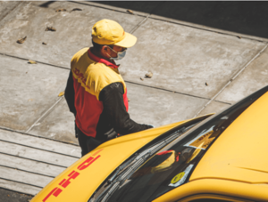 DHL Paketbote an Zustellfahrzeug