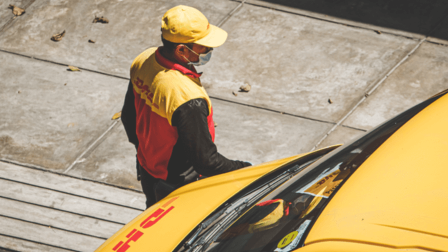 DHL Paketbote an Zustellfahrzeug