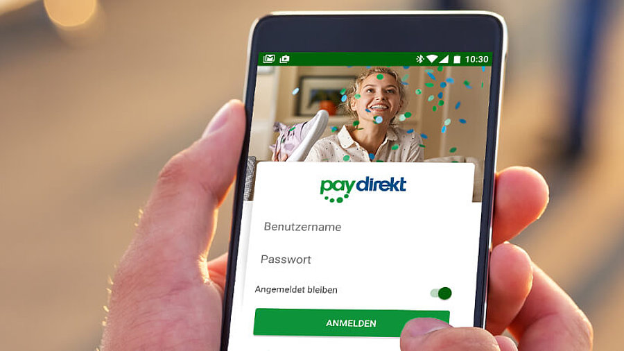 Nutzer mit einem Smartphone in der Hand, auf dem man das Logo von Paydirekt sieht