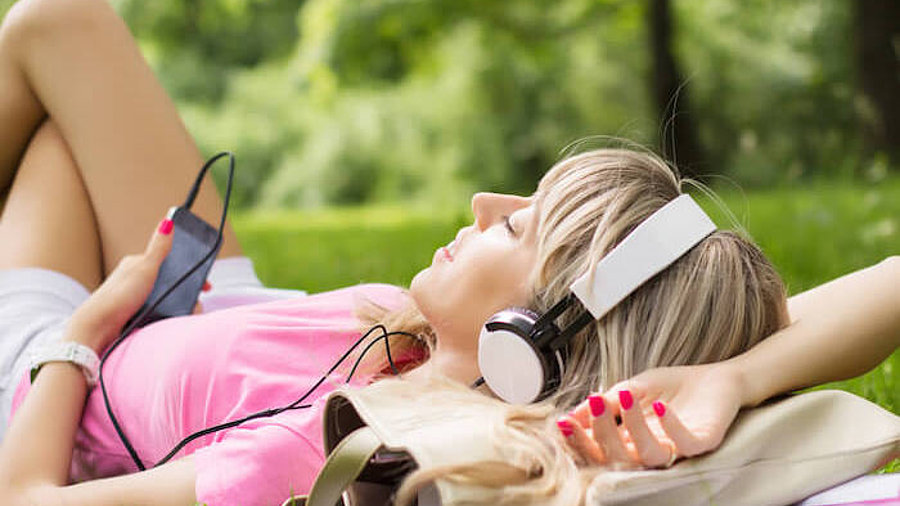 Frau streamt Musik im Park