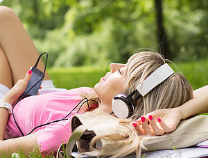 Frau streamt Musik im Park