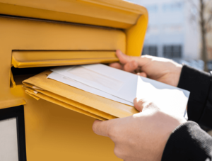 Deutsche Post: Briefe werden in Briefkasten gesteckt