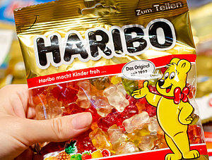 Hand h&auml;lt Haribo Goldb&auml;ren-T&uuml;te