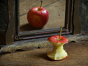 Verkehrtes Spiegelbild: Ein Apfel vor einem Spiegel