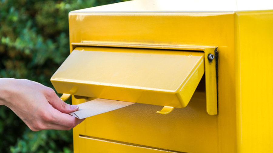 Brief in Briefkasten werfen