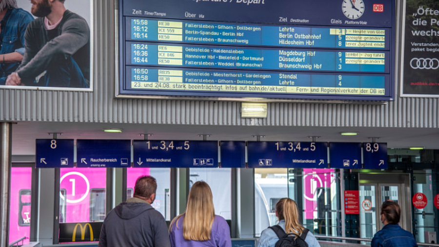 Bahnreisende vor Anzeigetafel