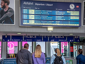 Bahnreisende vor Anzeigetafel