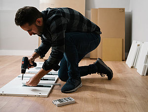 Mann baut Schrank auf