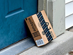 Amazon-Paket, das an einer Haustür lehnt