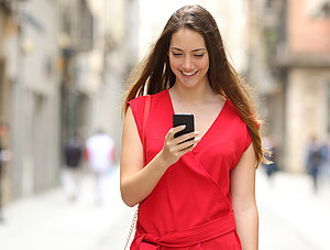 Frau l&auml;chelt auf Smartphone