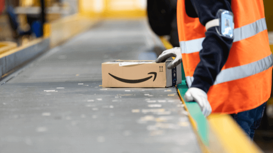 Amazon-Logistik-Mitarbeiter mit Paket an einem Fließband