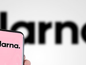 Klarna-Logo auf Smartphone und im Hintergrund