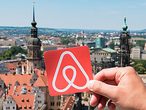 Airbnb Logo vor M&uuml;nchen Skyline