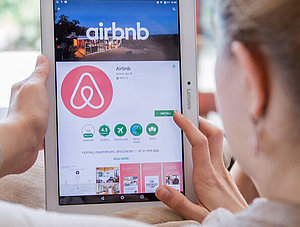 Frau mit iPad und AirBnB