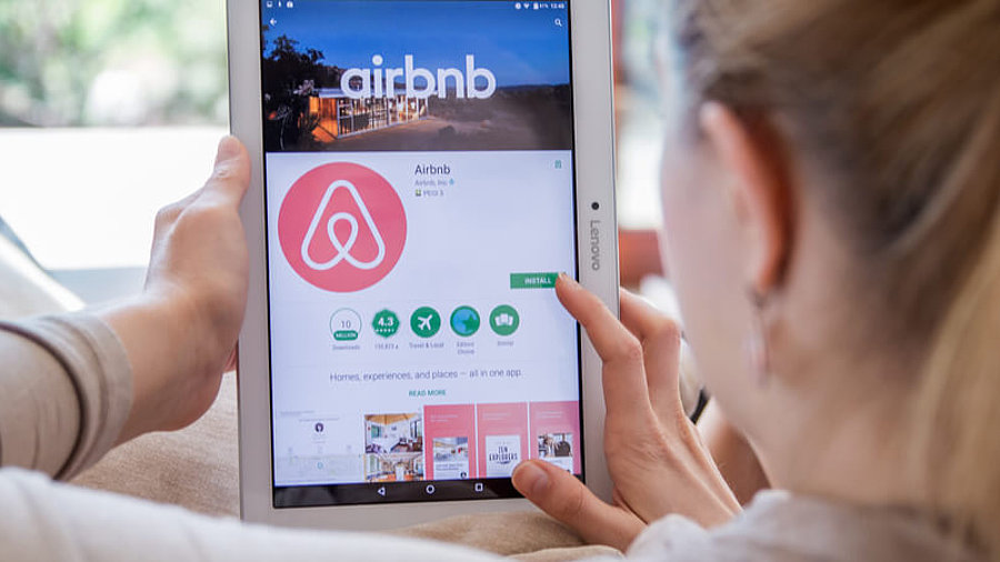 Frau mit iPad und AirBnB