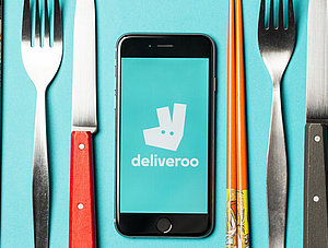 Essbesteck und Deliveroo-Logo auf Smartphone