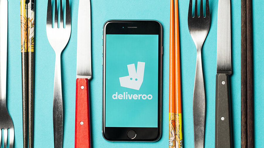 Essbesteck und Deliveroo-Logo auf Smartphone