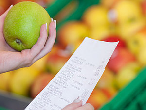 Frau mit Apfel und Kassenzettel