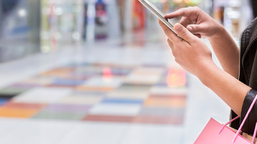 Frau mit Smartphone und Einkaufst&uuml;ten