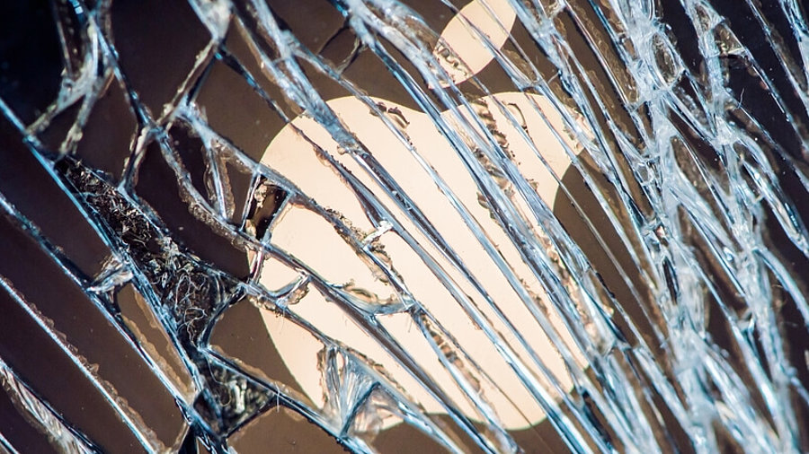 Apple-Logo hinter einer zersplitterten Glasscheibe