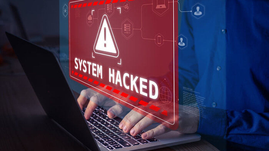 Person am Laptop hat sich in sein System gehackt Warnmeldung