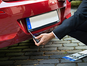 Mann wechselt Auto-Kennzeichen